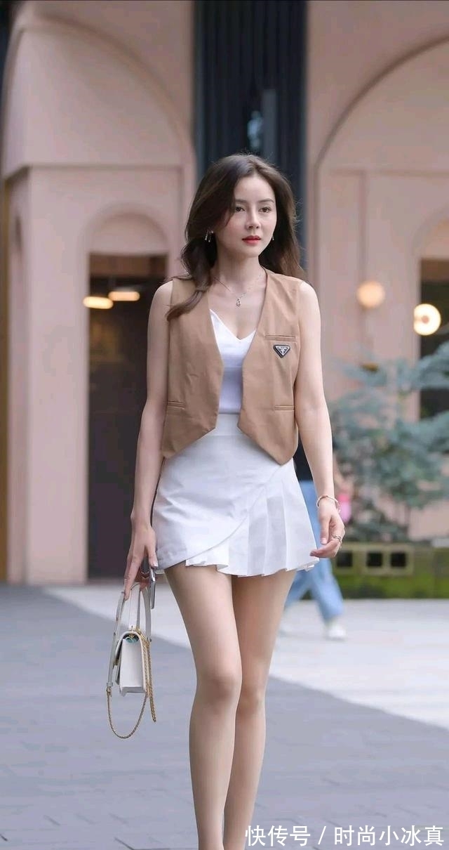 双臂 白色背心加棕色马甲,搭配米白色半身裙,展示白嫩双臂和修长美腿