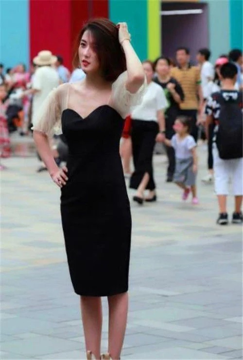 街拍:小姐姐皮肤白皙,穿黑色吊带连体裤,减龄又吸睛