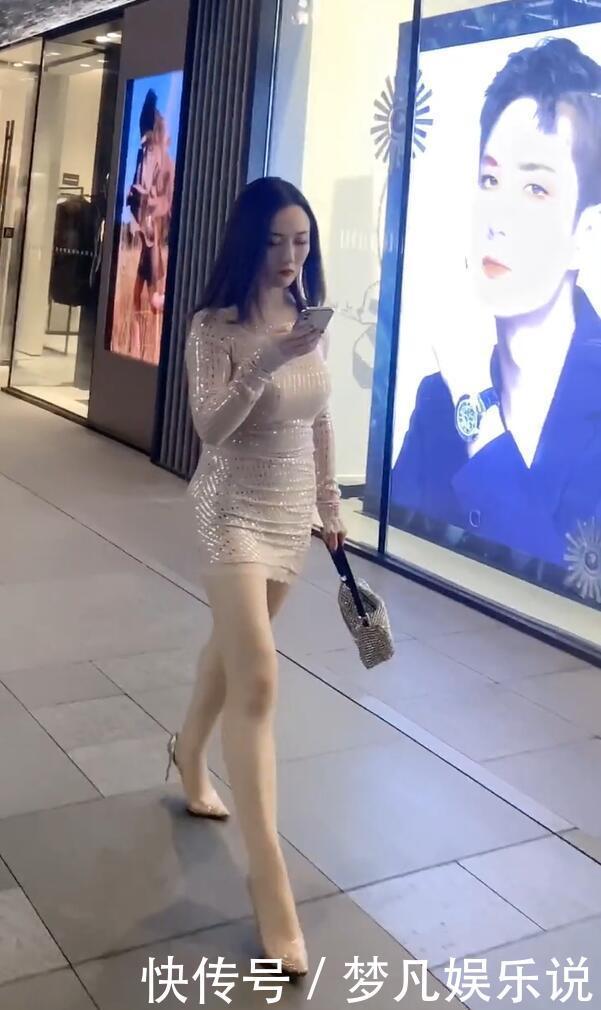 打扮精致的街头美女，泛光短裙配尖嘴高跟，时尚有个性