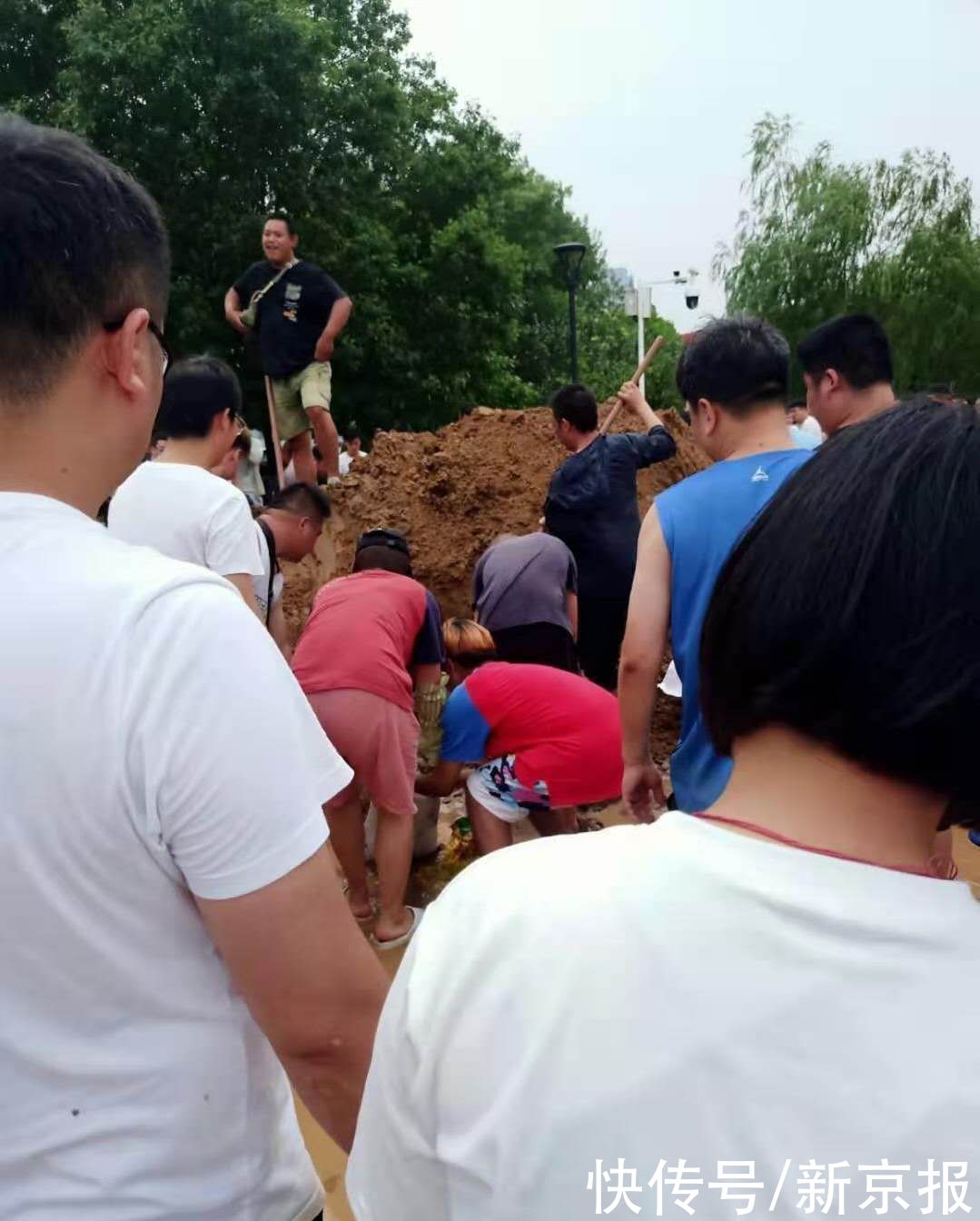 刘典青|新乡牧野湖倒灌，青年志愿者受召唤前往筑堤，现场千人接力运沙袋