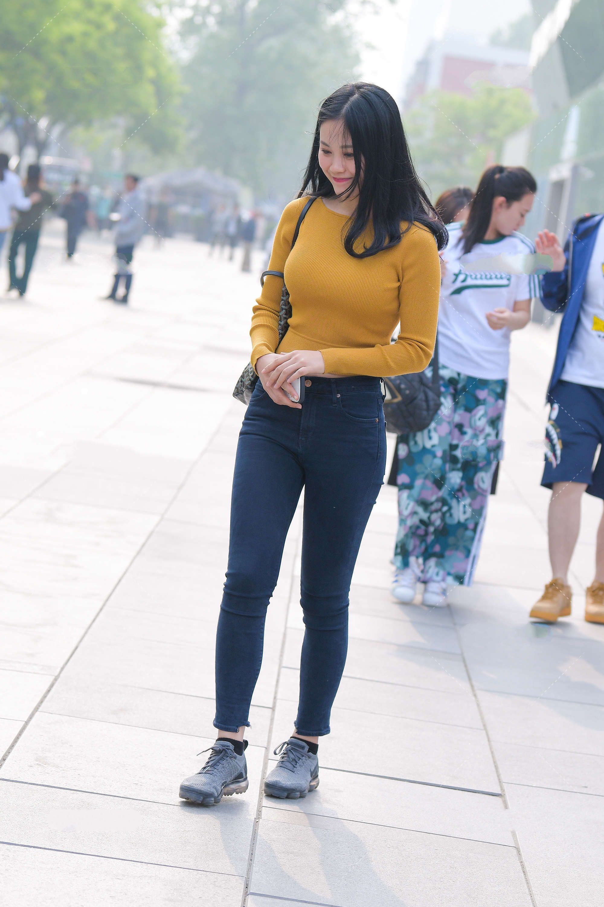 暗黄色针织上衣，与黑色牛仔裤组合，展示温柔淡雅一面