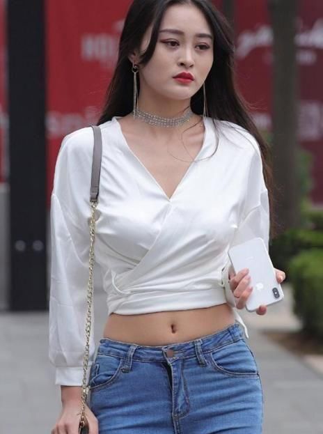 时尚街拍:白色V领+紧身牛仔裤,时尚与品位兼具,打造魅力女神气质