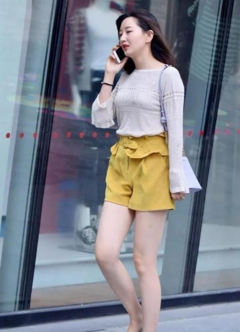 街拍美女身穿黑色的短袖,搭配着天蓝色的牛仔裤,很完美