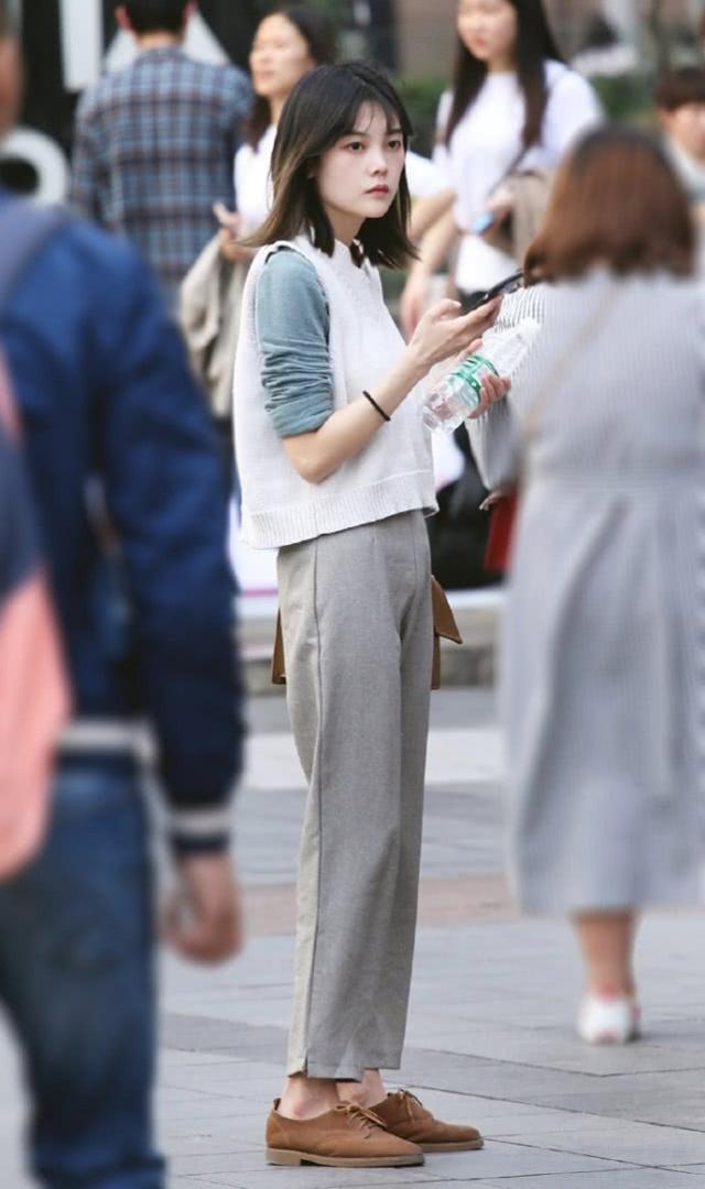 街拍:美女白色毛线背心搭配灰色休闲裤,简约唯美而且显出典雅的气质