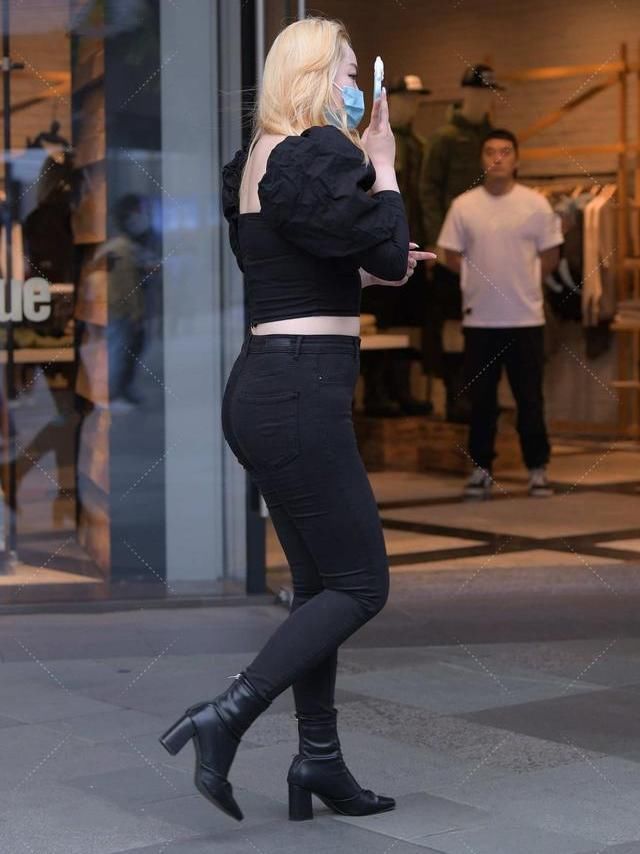 黑领口上衣，宽松的袖口设计，与同色牛仔裤相配，展现别样气质