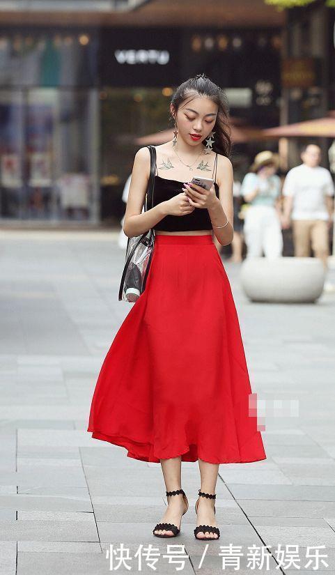 街拍美女身穿吊带的紧身裙，搭配一双靓丽的高跟鞋，更显摩登时尚范