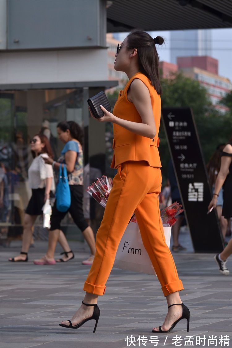 街拍 街拍:小姐姐橙色的套装,扎一个半丸子头型,显得人很精致!