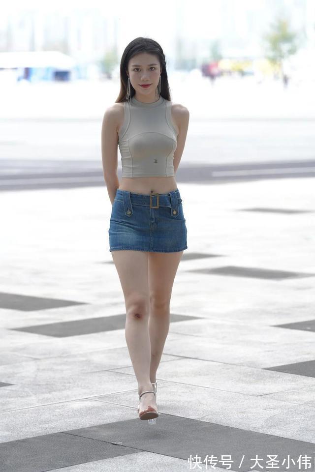 无袖背心 美女街拍:短款无袖背心搭配牛仔短裙,凸显香肩、小蛮腰和美腿,魅力炸街