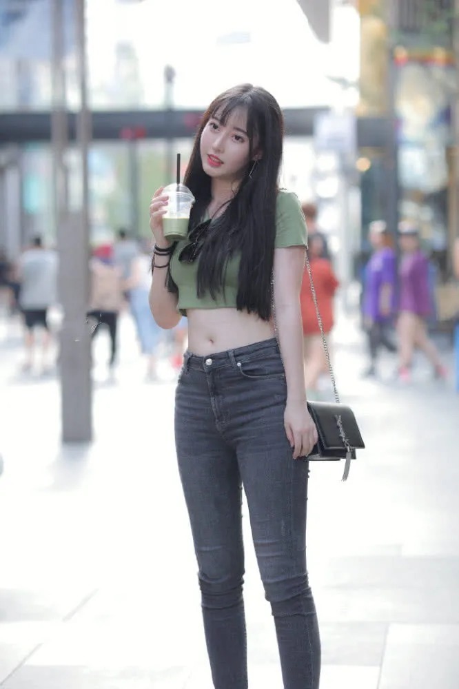 五官精致的小姐姐留着黑直长,穿着绿色的短T恤和牛仔裤,可爱又好看