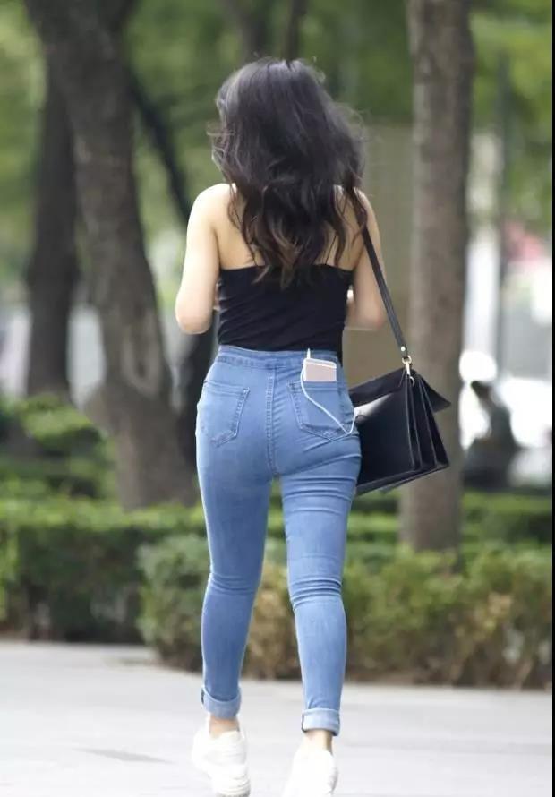 吊带|街拍黑色吊带背心搭紧身牛仔裤的性感姑娘,大方洒脱的气质