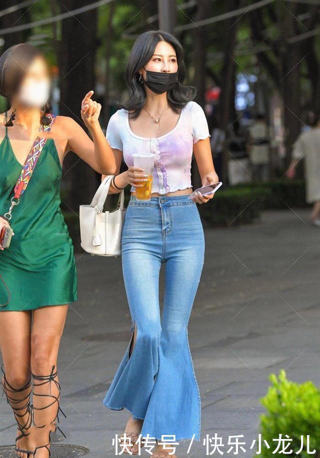牛仔裤高腰喇叭裤搭露脐短T,齐肩的微卷秀发,散发着成熟的韵味