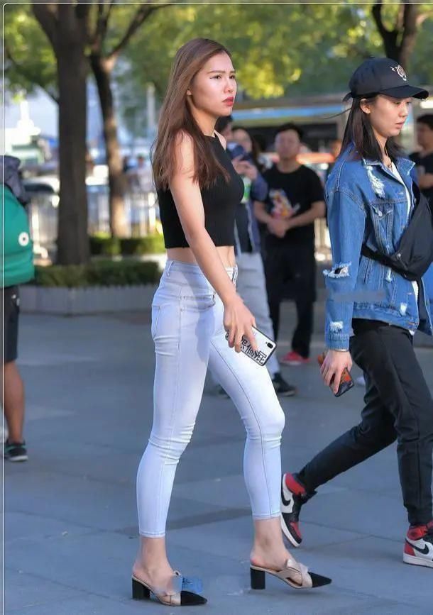 美女黑色无袖短款背心搭浅白色牛仔裤,在人群中具有非常明确显眼
