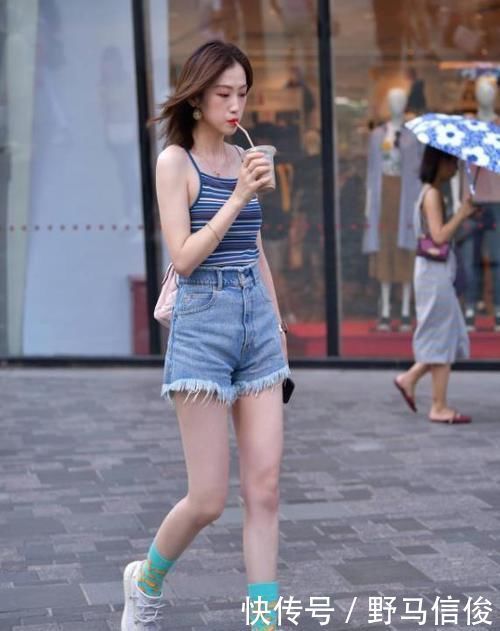 街拍小姐姐半袖上衣搭配黑色的短款下装,非常时尚具有美感