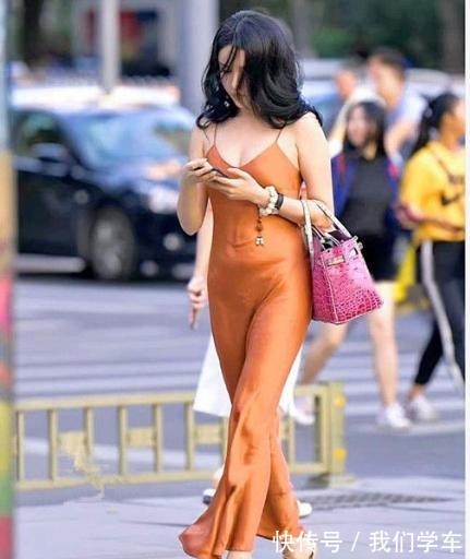 女士 橙色小吊带裙搭配粉色包包,贴身舒适,展现成熟风情!