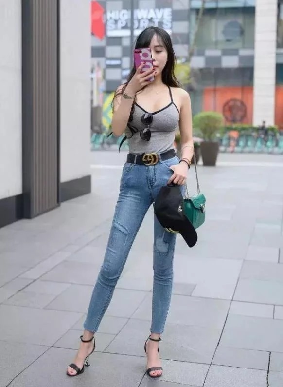 长裤|街拍:身材高挑的美女,身穿吊带配牛仔长裤,时尚优雅美丽大方