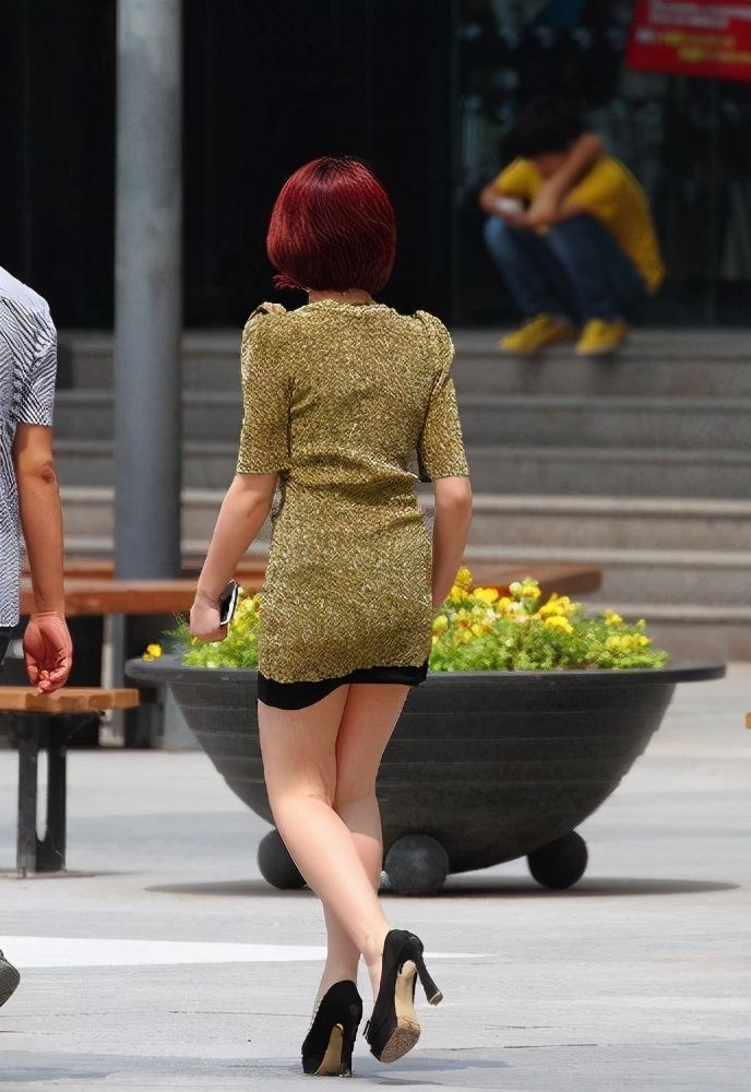 街拍:红头发美女穿一身靓丽的连衣短裙上街,酷劲十足