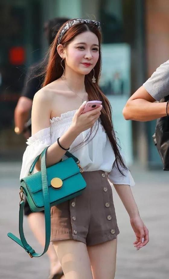街拍美女:雪纺一字肩搭配时装短裤,手挎绿色包包,尽显时尚潮流