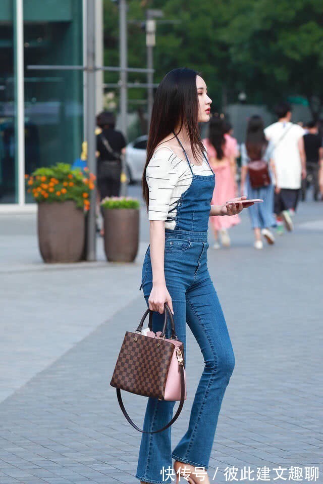 吊带裤 牛仔吊带裤搭配白色V领上衣,散发时尚韵味,彰显高挑身材