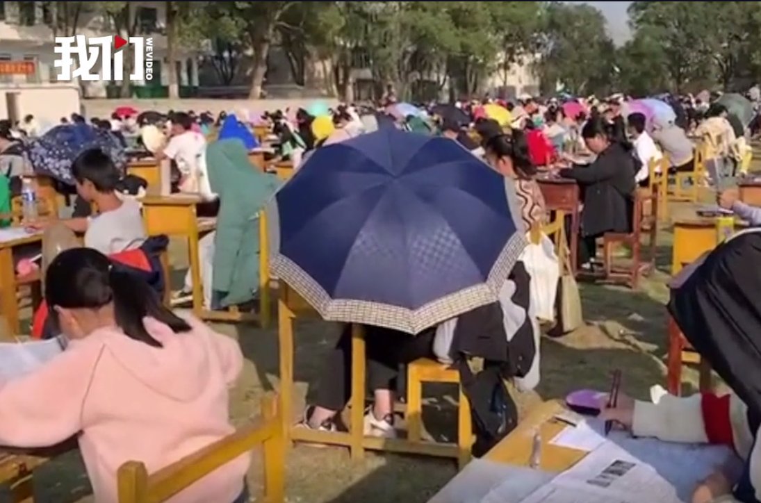 操场上|湖南一学校试行在操场上进行期中考试，有学生因太晒撑伞参加