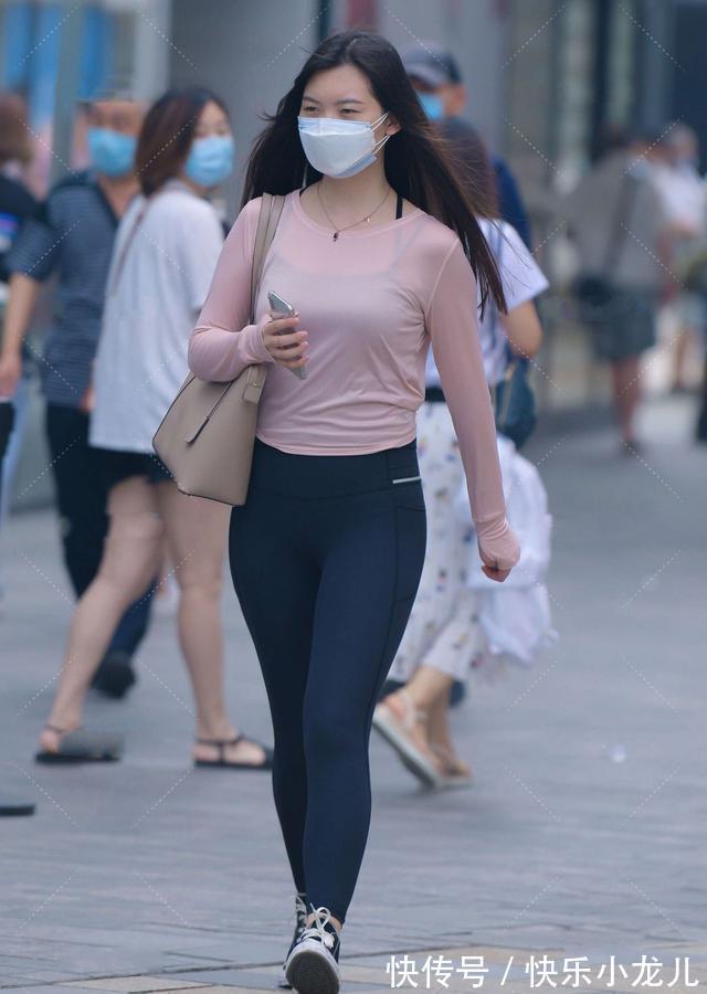 下身为 黑色运动裤搭配淡粉色长袖,贴身舒适又透气,青春有朝气