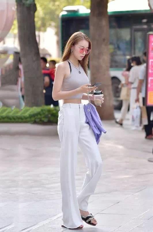 街拍:身材苗条的时尚美女,柔美的桔色上衣搭配牛仔裤,优雅大方