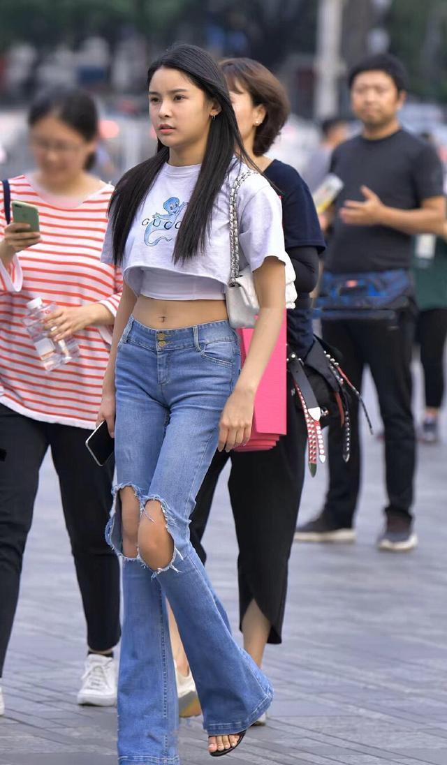 女孩子 露脐T恤搭配紧身牛仔裤，迷人身材羡慕众人，美到闪闪发光