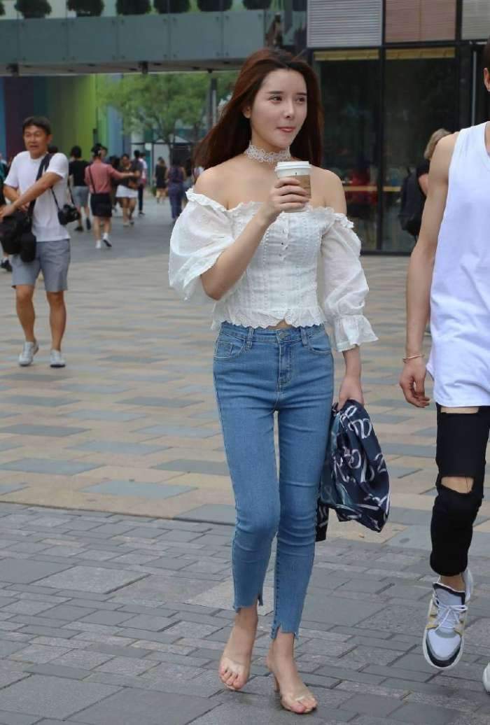 展现|街拍:美女穿着白色的抹胸上衣搭配牛仔裤,美腿曲线完美的展现!
