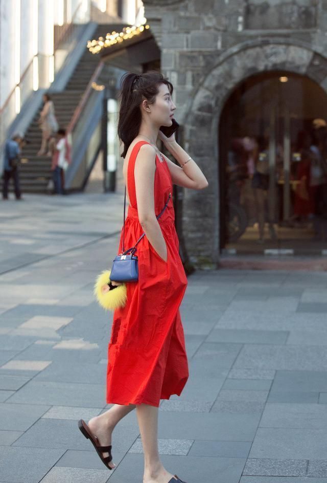 街拍|行走在街头的马尾美女,一身露背红吊带裙装,醒目又耀眼