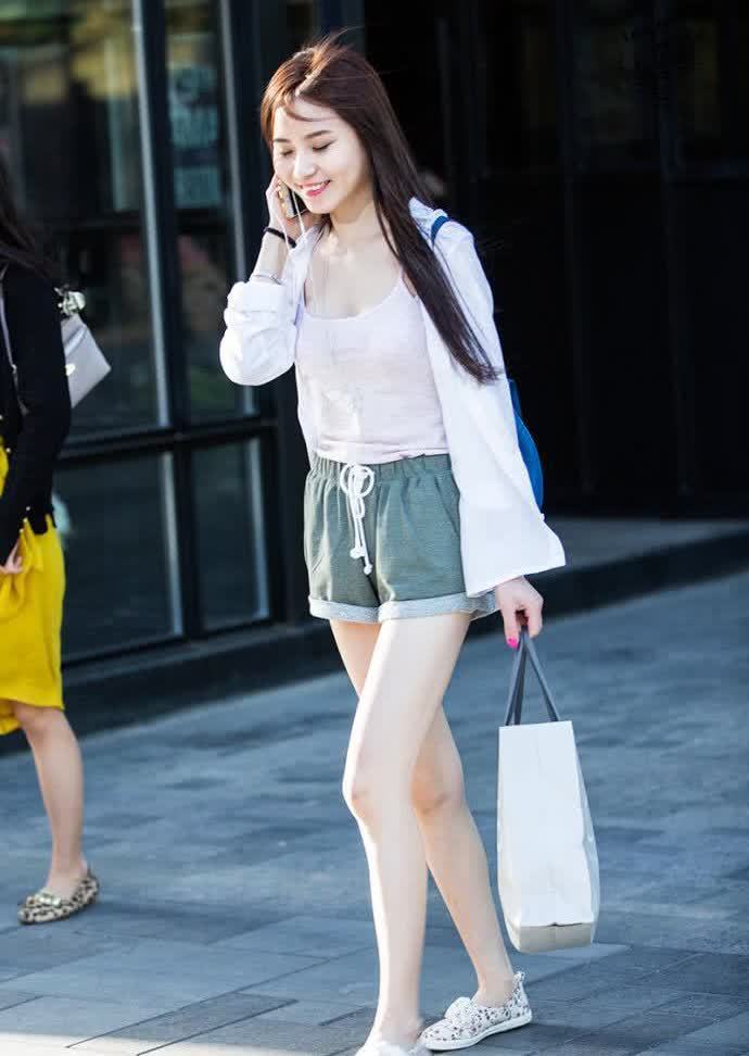 纤瘦|街拍:紧身上衣配灰黑色的短裙,小姐姐的身材高挑纤瘦,简单又时尚