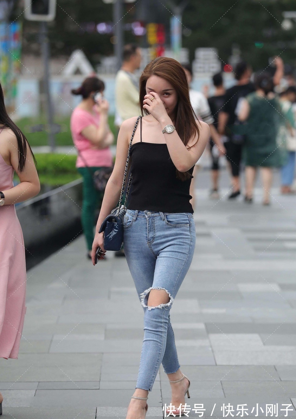 紧身牛仔裤 小姐姐身穿黑色吊带,搭配蓝色紧身牛仔裤,看上去时尚大方