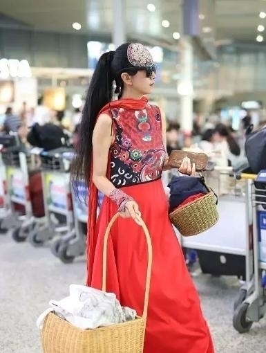 机场|60多岁的杨丽萍活出了自信,穿红色民族裙走机场,推竹筐好洋气