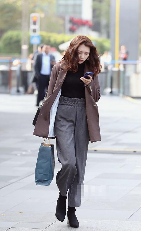 小姐姐|美女上衣是棕色系的西装，内搭是黑色修身的T恤，气场蛮不错的呢
