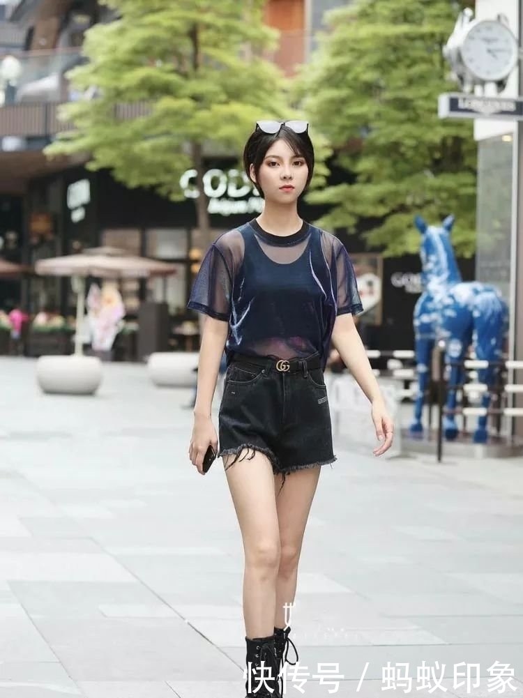 街拍:黑色毛边牛仔短裤同色上衣更显层次感,颜色搭配和谐统一