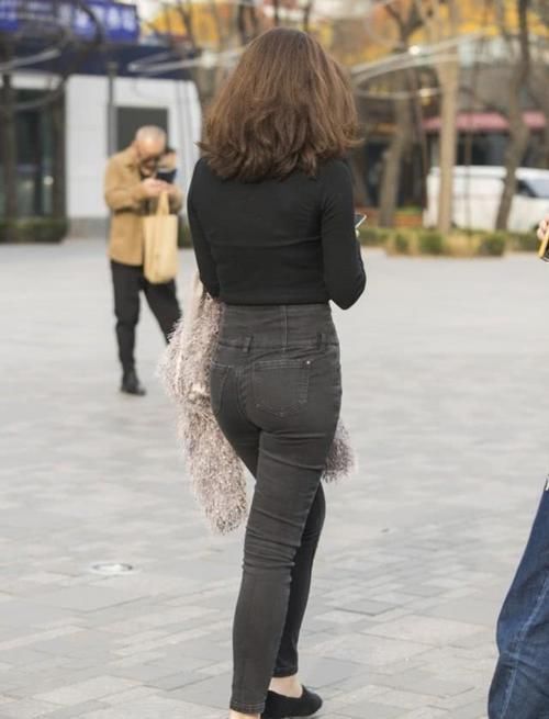 街拍小姐姐绿色针织衫搭配休闲牛仔裤，给人一种美丽优雅的感觉