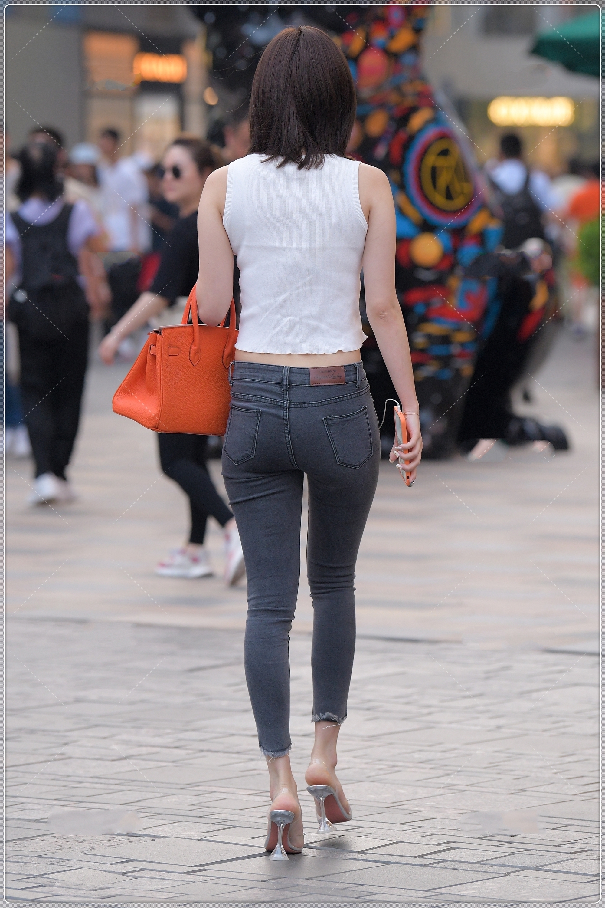 修身牛仔裤 夏季简单的白色背心,搭配露膝牛仔裤很时髦,简约时尚