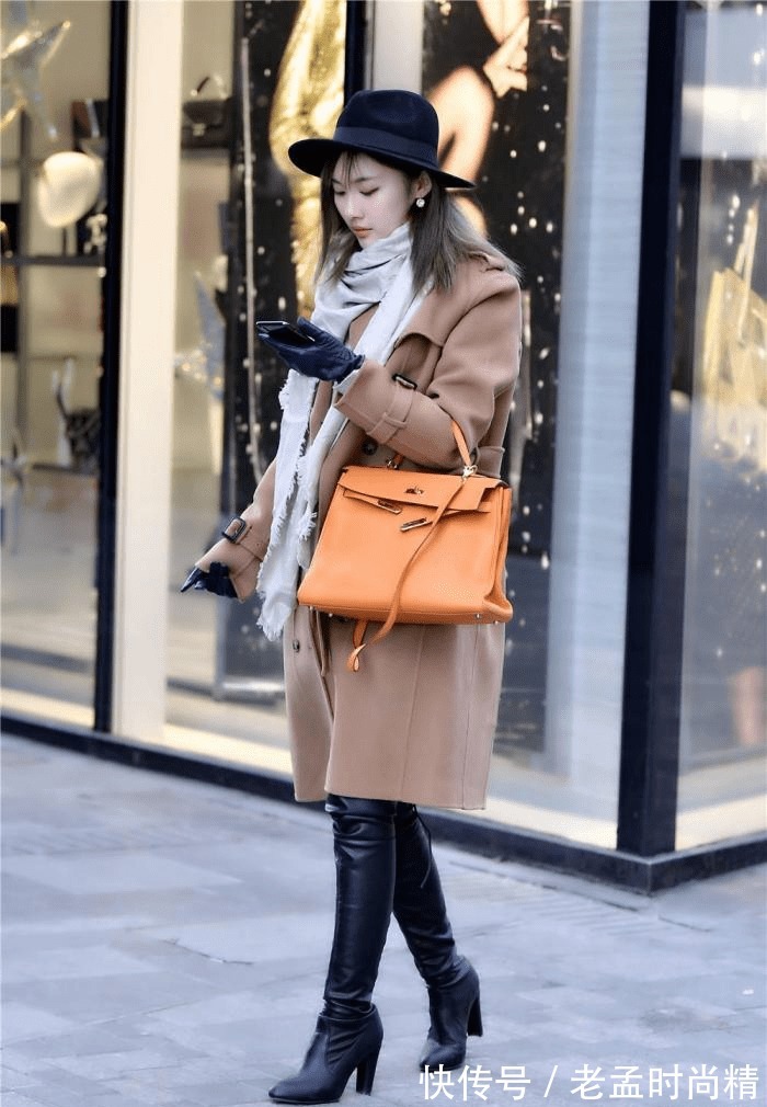 身材高挑 棕色呢子大衣,搭配黑色过膝皮靴,粗跟款式,衬托身材