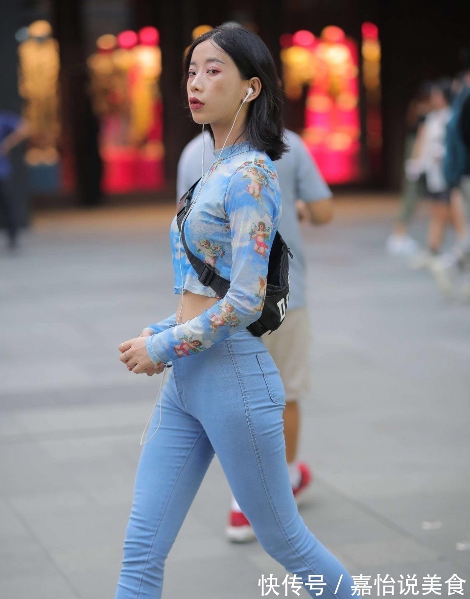紧身牛仔裤 小姐姐身穿蓝色紧身牛仔裤,搭配一件扎染的上衣,看上去很时尚