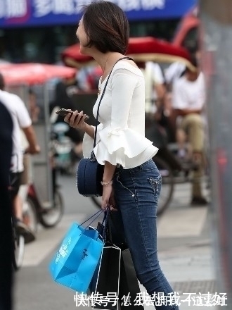 街拍|街拍：紧身牛仔裤搭配白色露肩装的美女，甜美笑容让人印象深刻