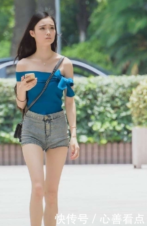 紧身衣|街拍:小姐姐下穿高腰牛仔短裤上面搭配蓝色露肩紧身衣,非常漂亮