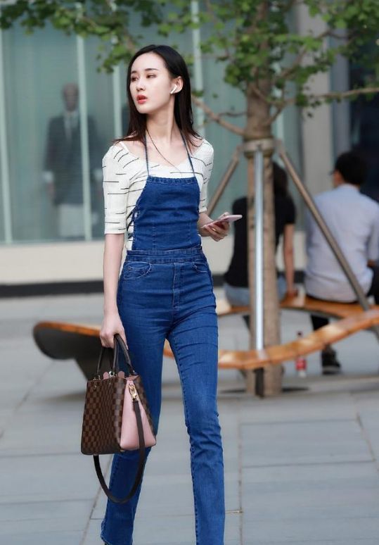 街拍:小姐姐身穿紧身裙,配黑色的小包,看上去是很有气质