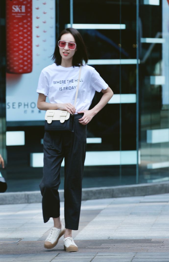 街拍：身材高挑的美女，黑色的牛仔裤搭配针织背心，彰显年轻的风采