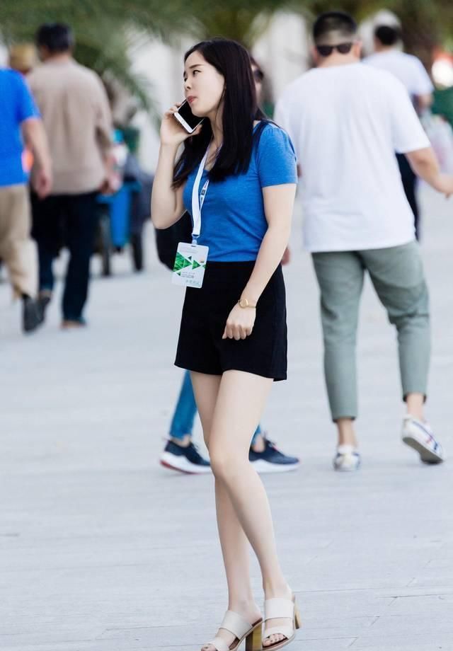 短袖|街拍黑色休闲短裤搭配蓝色短袖T恤,小姐姐打电话的姿势要优雅