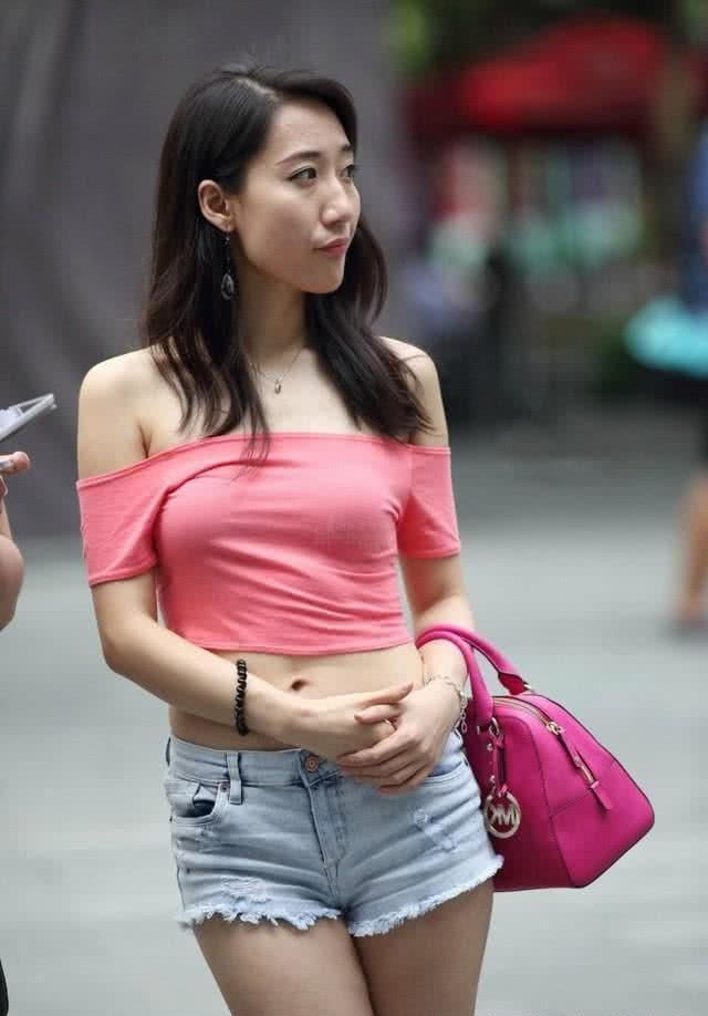 街拍美女白色紧身小背心,落落大方,尽显性感好身材