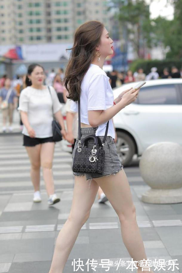 一件蓝色斜肩打底衫搭牛仔短裤，整个造型显得优雅又利落