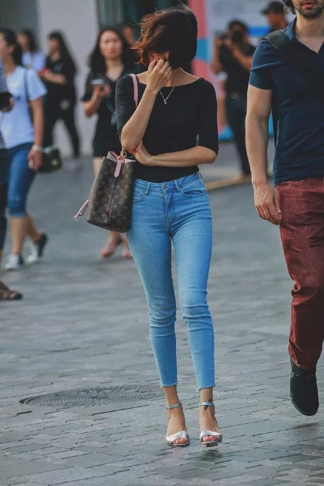 街拍:美女身穿黄色毛衣搭配小皮裙,笑容甜美可爱,非常时髦