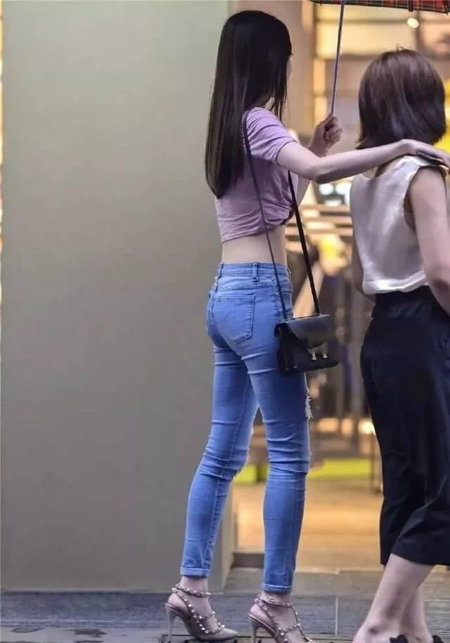 街拍美女小姐姐紧身牛仔裤尽显凹凸身材,回媚一笑却迷倒一大片