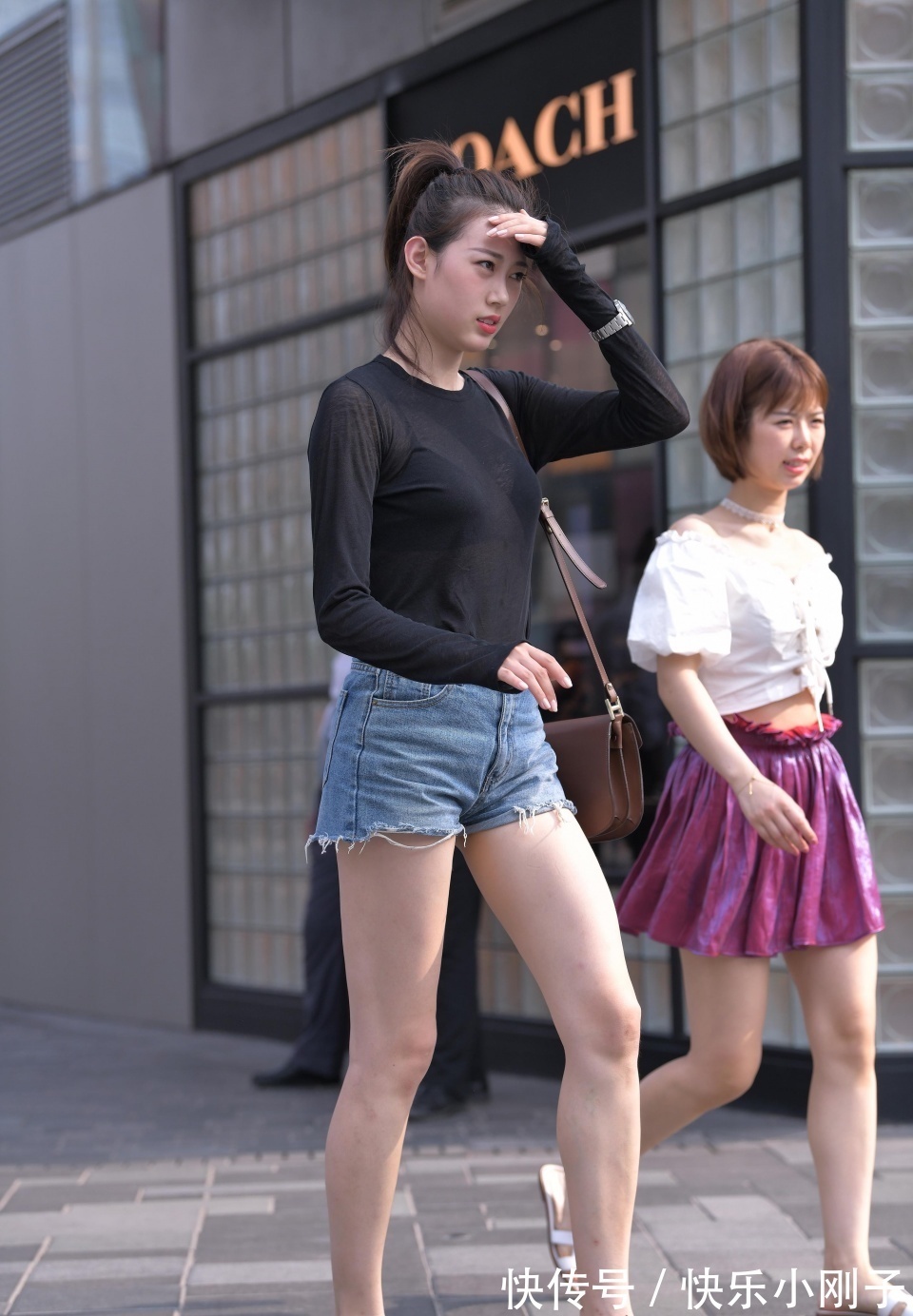 高女孩|小姐姐身穿黑色的长袖,搭配黑色的牛仔短裤,走在街上很时尚大方