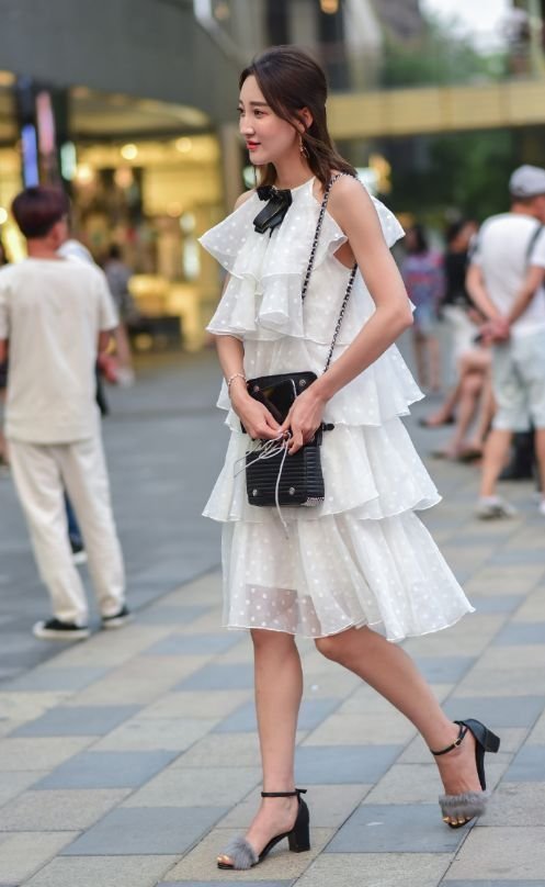 身穿蛋糕裙的小姐姐,裙身的版型立体,彰显出甜美俏皮的感觉