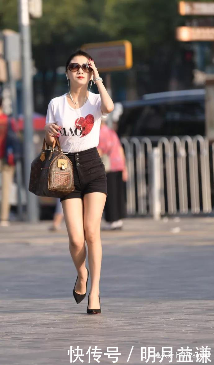 美女脚上踩着一双黑色的高跟凉鞋，让她出街的时候带着优雅的姿态