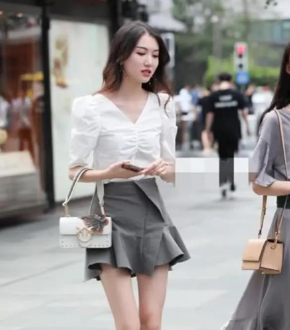 街拍名嫒美姝的美女,身穿V领上衣配灰色裤子,彰显时尚达人气质